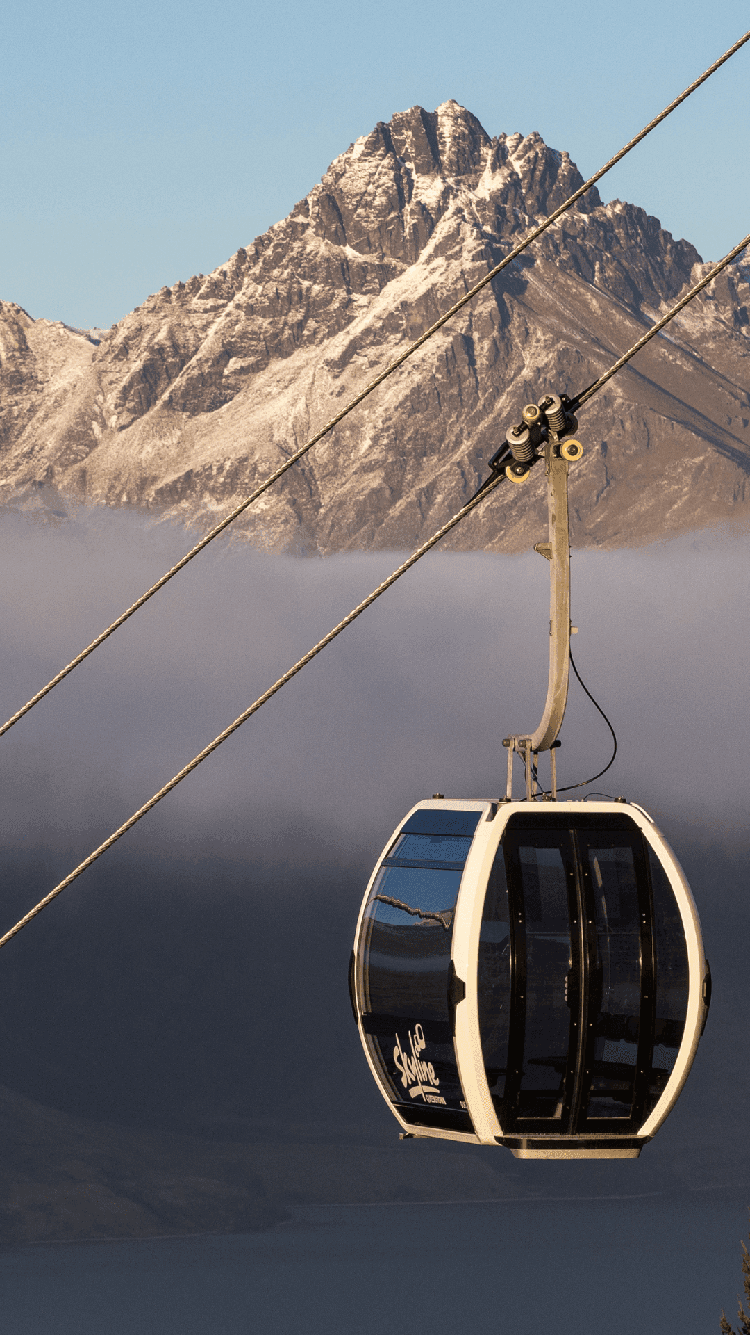 Image of the Gondola rises from the mist with mountains in the background